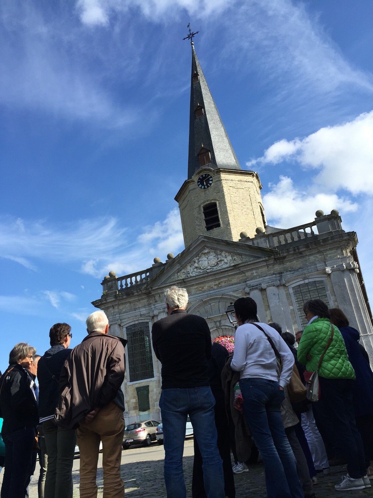 Foto van mensen die naar de Sint-Martinuskerk in Moerzeke kijken
