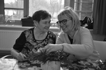 Bewoner schikt bloemen met vrijwilliger
